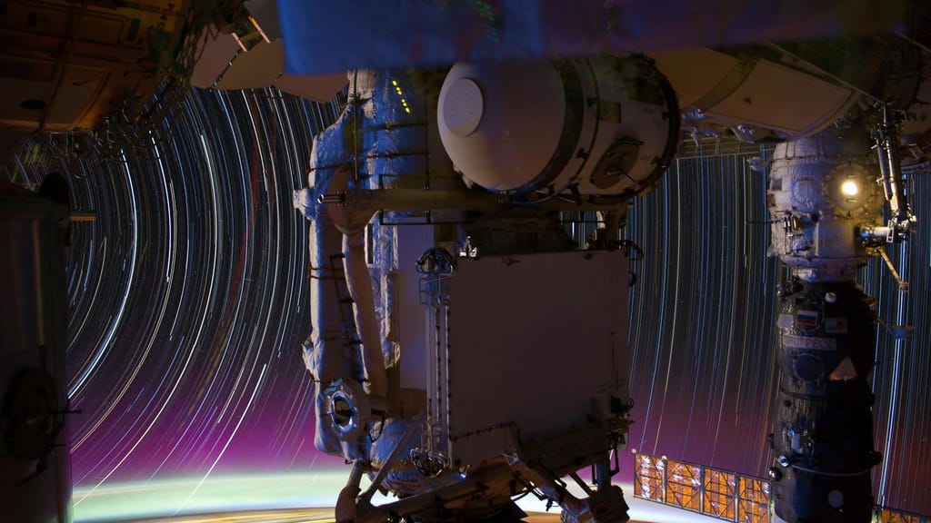 Rastos circulares de estrelas por trás da estrutura da Estação Espacial Internacional